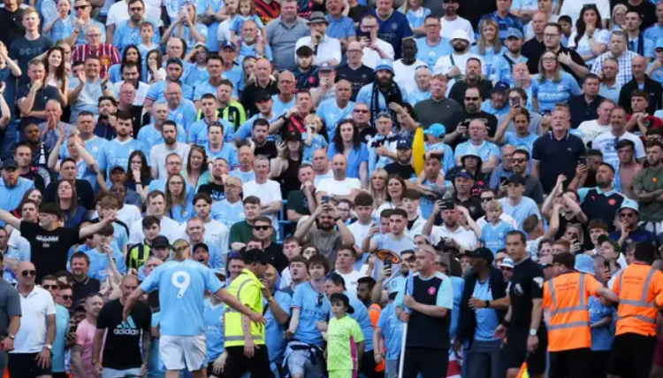 Man City fans invade pitch BEFORE full-time of West Ham game as annoyed players then race for cover behind police to be able to celebrate Premier League title win